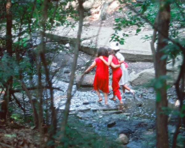 The Woman in Red, the Teenager in Magenta, and the Little Girl in Pink Sash wade the stream, performance Rivers First Draft by Lorraine O’Grady.